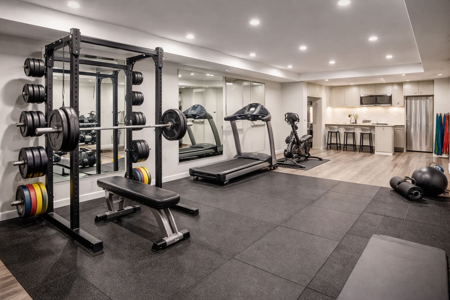 Finished basement home gym with weight rack, treadmill, rubber flooring, and modern lighting in an Edmonton home